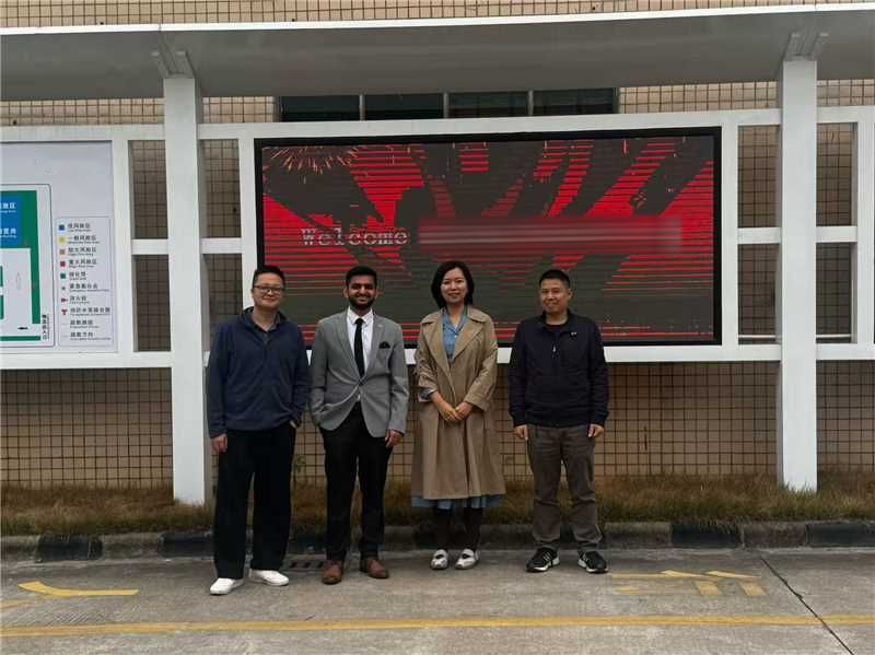Welcoming a visiting buyer at a factory gate
