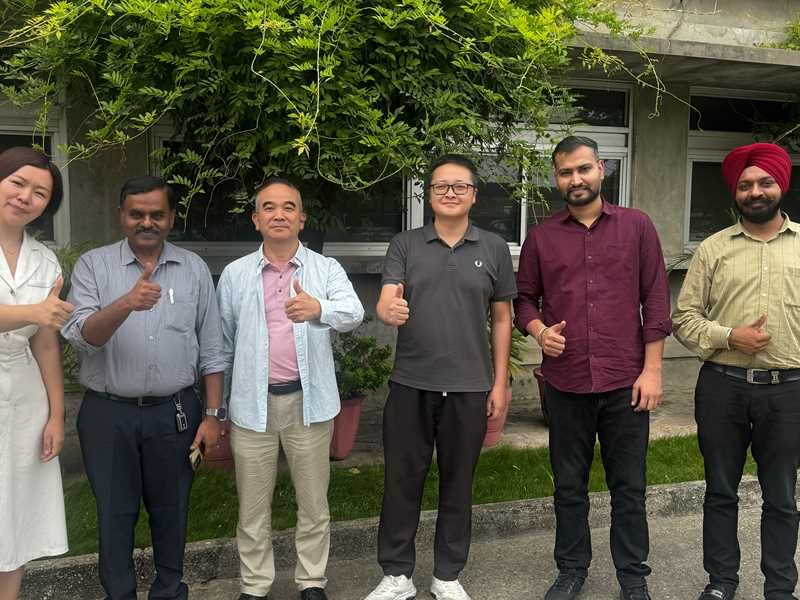 Group photo with visiting buyers outside a factory building
